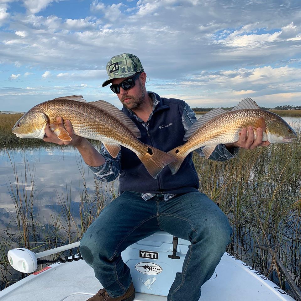 Double redfish hookup on a skiff