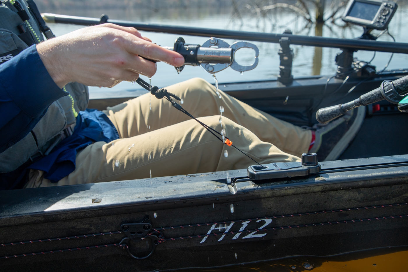 Track mounted retractor used to secure fish grips on a kayak